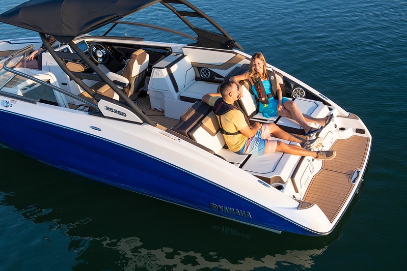 Two people are having a conversation sitting in the back of an anchored boat